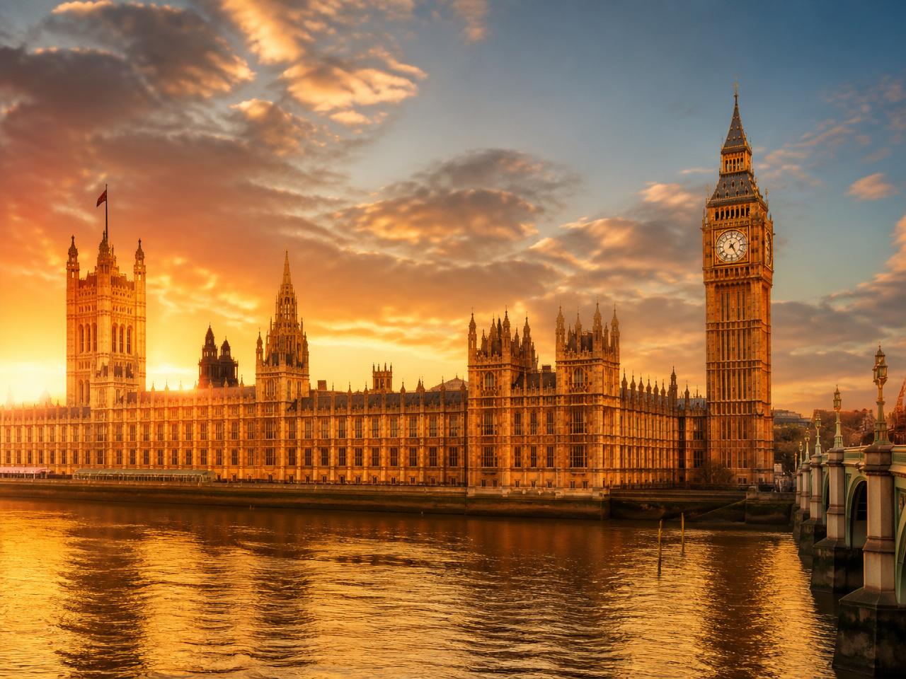 The Houses of Parliament and Big Ben clock tower in Westminster glowing at golden hour over the River Thames